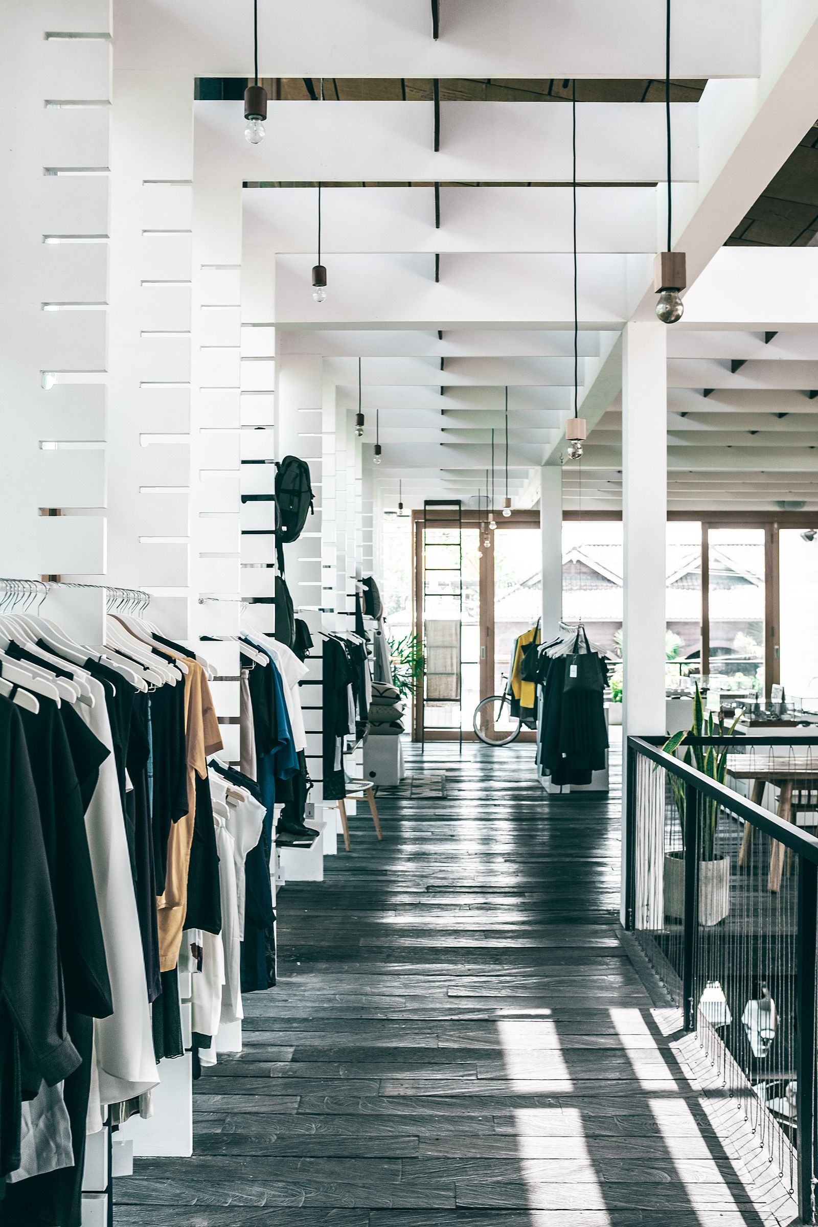 Spacious fashion showroom with clothing displayed on multiple racks